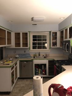 a kitchen with white cabinets and green trim