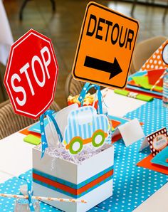 a table topped with boxes and signs on top of blue polka dot tables cloths