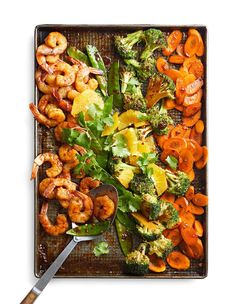 a tray with shrimp, broccoli and carrots