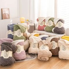 a pile of blankets sitting on top of a hard wood floor next to a window