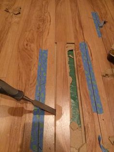 a pair of pliers laying on top of a wooden floor with blue tape around it