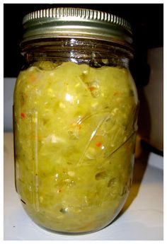 a jar filled with pickles sitting on top of a table