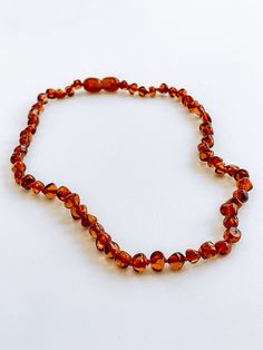 a necklace made out of glass beads on a white surface