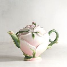 a pink and green tea pot with a rose on it