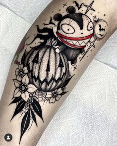 a black and white tattoo on the leg of a person with a pumpkin in it