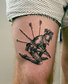 a man with a tattoo on his leg that has an arrow and bow in it