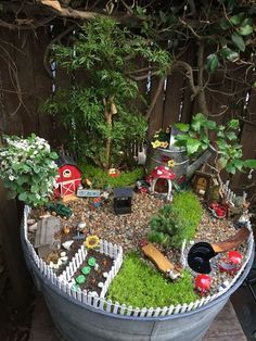 a potted planter filled with lots of plants and small toy cars in it