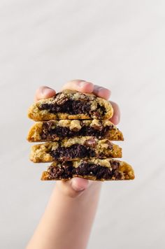 a person holding three cookies in their hands