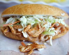 a pulled pork sandwich with coleslaw and carrots