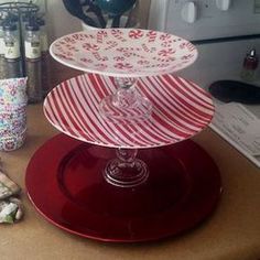 three tiered cake stand on top of a counter next to wine glasses and other items