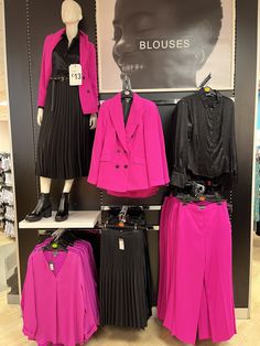 pink and black clothing on display in a store with mannequins wearing clothes