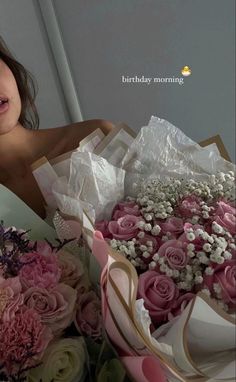 a woman sitting in front of a bouquet of flowers