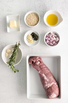 raw meat and ingredients laid out in bowls on a white counter top, including onions, garlic, parmesan cheese, butter, olives, and oil