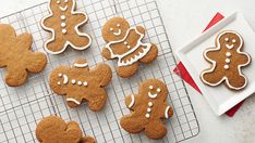 some cookies are on a cooling rack and one is decorated with icing, the other has gingers