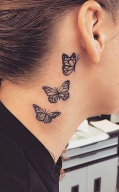 a woman's neck tattoo with three butterflies on her left side and behind the ear