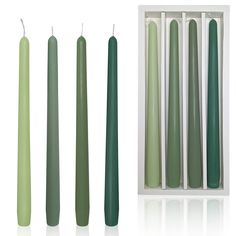 green candles are lined up next to each other in a white box and one is empty