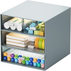 a metal box with several compartments filled with office supplies and markers on the bottom shelf