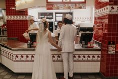 a bride and groom are standing in front of the counter at a fast food restaurant