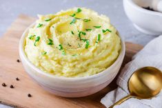 mashed potatoes with sprinkles in a white bowl on a wooden cutting board