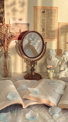 an open book sitting on top of a table next to vases with flowers in them