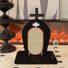 a black and white chair with a cross on it sitting in front of a fireplace