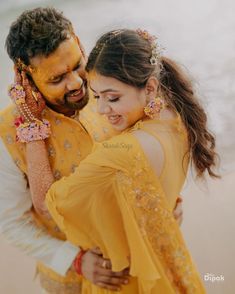 a man and woman dressed in yellow hugging each other