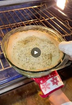 someone holding a pie in front of an open oven with snowflakes on it