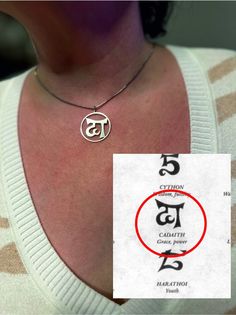 a close up of a person wearing a necklace with the letter t in it's center