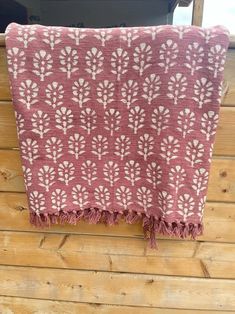 a pink and white towel hanging on the side of a wooden wall