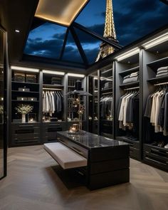 a walk - in closet with an open glass ceiling and clothes on hangers, lighting up the room