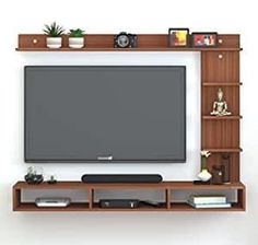 a flat screen tv mounted to a wall with shelves on each side and bookshelves below