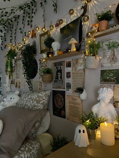 a bedroom decorated for halloween with plants and decorations on the wall, candles and pictures