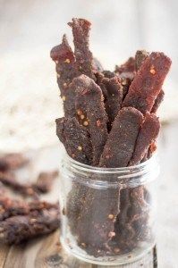 a jar filled with brown dog treats sitting on top of a table