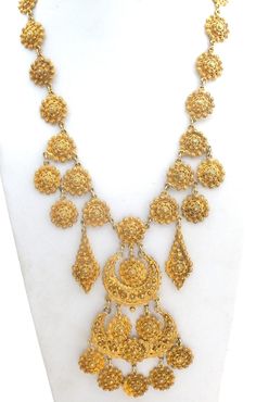 Statement Jewelry - This is a Egyptian style gold tone bib necklace with a design that looks like cannetille. It is 21" long, which includes the 2" extension, so necklace can be worn from 19" to 21" in length. The center from top to bottom is 5" long. Fabulous necklace. Gold Bohemian Long Bridal Necklace, Ornate Long Gold Necklace, Antique Gold Dangle Necklaces, Gold Bib Necklace Costume Jewelry, Gold Costume Jewelry Bib Necklace, Ornate Gold Medallion Necklace, Gold Filigree Dangle Necklaces, Gold Costume Jewelry Necklace With Intricate Design, Ornate Gold Necklace With Large Pendant