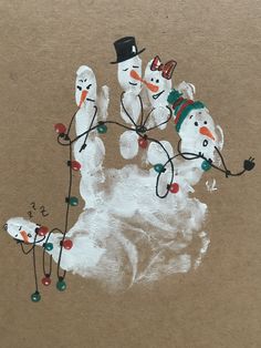 an image of snowmen with hats and lights on their hands painted on brown paper