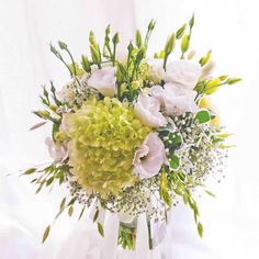 a vase filled with white and green flowers