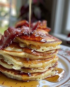 a stack of pancakes with syrup being drizzled on top