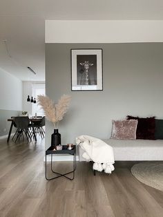 a living room filled with furniture and a white couch next to a wooden floor covered in pillows