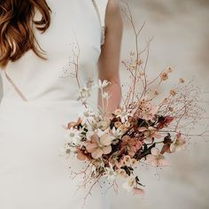 a woman in a white dress holding a bouquet of flowers