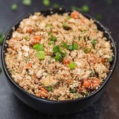 a black bowl filled with food on top of a table