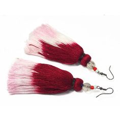 two red and white tassels with black beads on each earring are shown