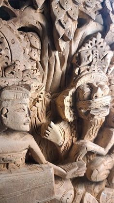 carved wooden carvings depicting two men and one woman