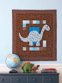 a blue and brown wall hanging over a dresser in a child's room with toys on it