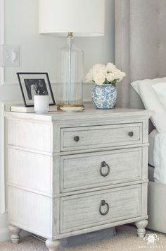 a white nightstand with flowers and pictures on it