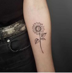 a woman's arm with a small sunflower tattoo on the left inner arm