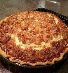 a pie sitting on top of a black pan covered in cheese and toppings,