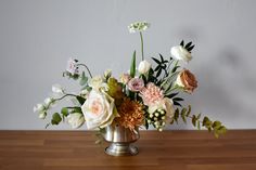 a vase filled with flowers on top of a wooden table