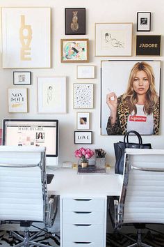 an image of a woman sitting in front of a desk with pictures on the wall