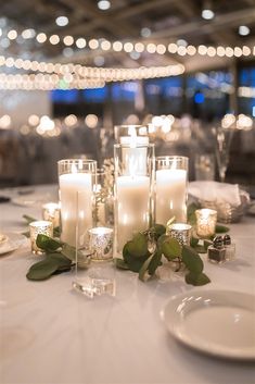 candles and greenery are on the table at a wedding reception in an elegant setting