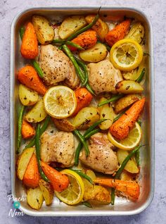 chicken and vegetables in a baking pan with lemons